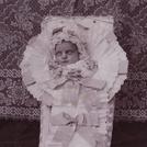 Baby in coffin with ribbons